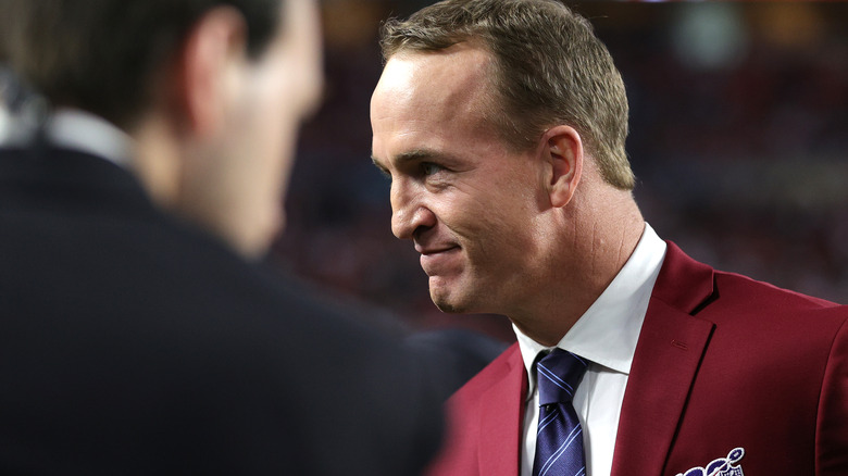 Peyton Manning grinning in red blazer