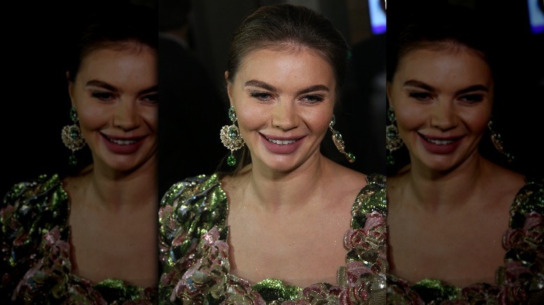 Alina Kabaeva, smiling, wearing a sparkles, and big earrings, 2018 photo