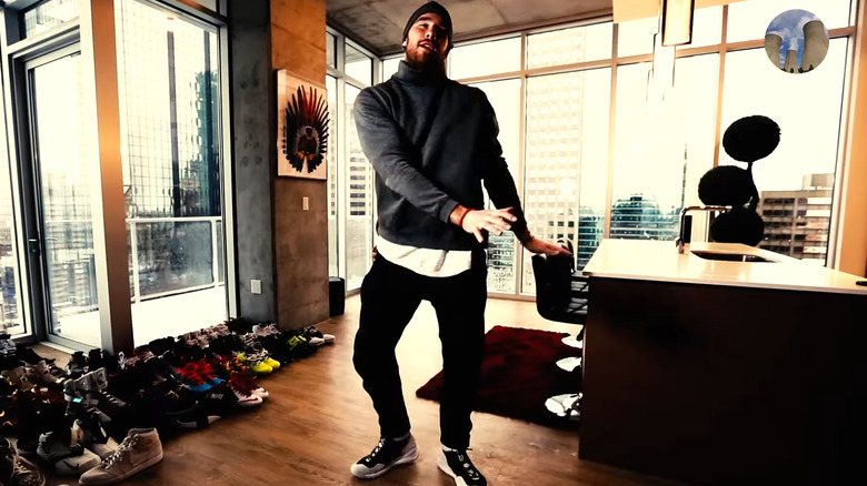 Travis Kelce dancing next to his shoe collection