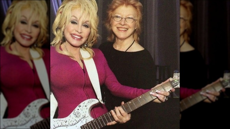 Dolly Parton and Judy Ogle smiling with guitar