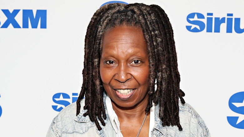 Whoopi Goldberg smiling and wearing a denim jacket