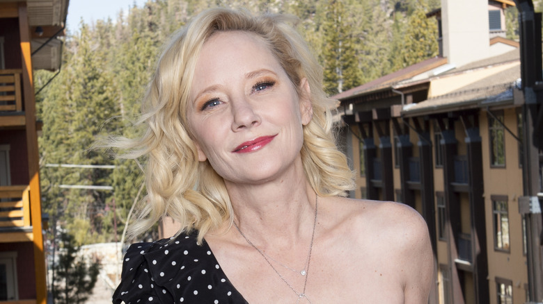 Anne Heche smiling in black and white polka dot dress