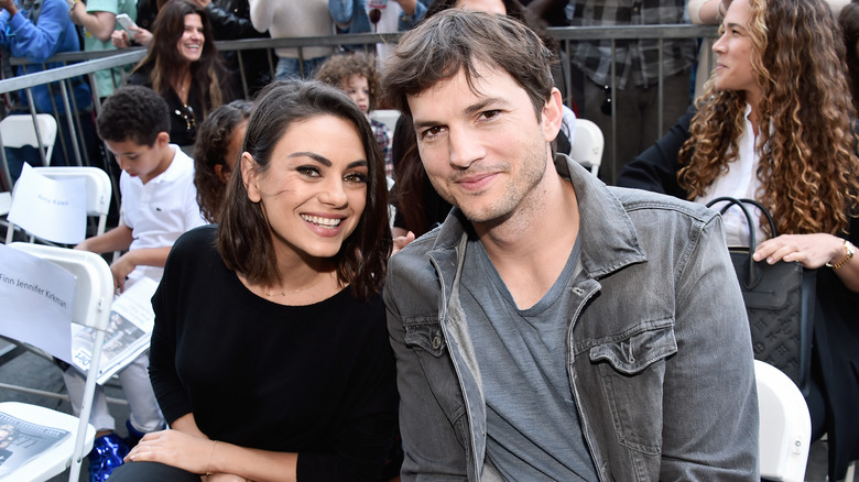 Ashton Kutcher and Mila Kunis smiling at an event