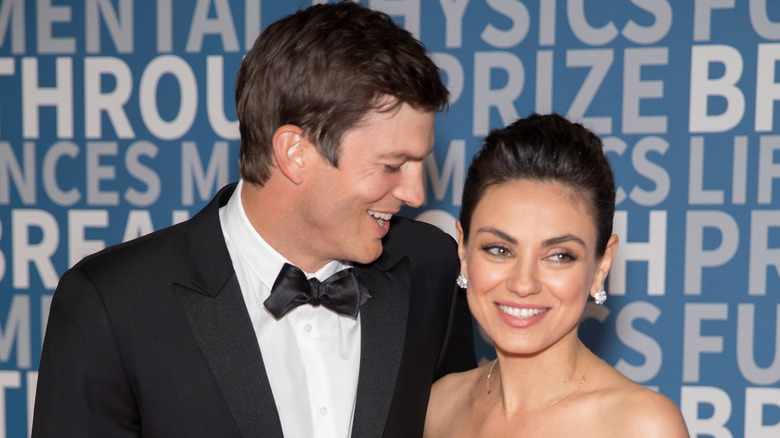 Ashton Kutcher and Mila Kunis smiling on the red carpet