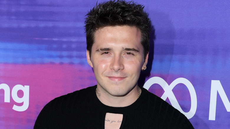 Brooklyn Beckham in black shirt on red carpet