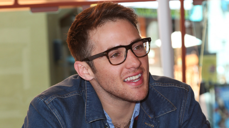 Casey Moss wearing glasses, smiling