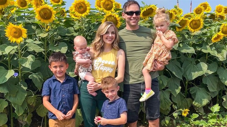 Jen Lilley and family smiling among sunflowers