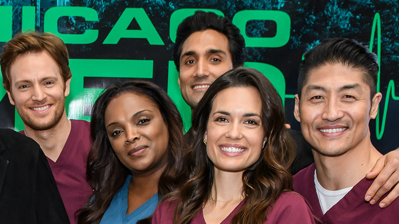 Torrey DeVitto smiling on set with cast of Chicago Med