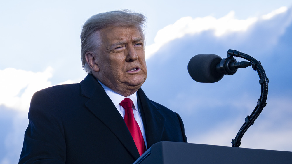 Donald Trump speaking into a microphone at a podium