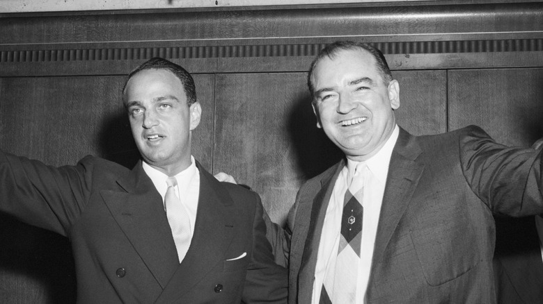 Roy Cohn and Joseph McCarthy waving