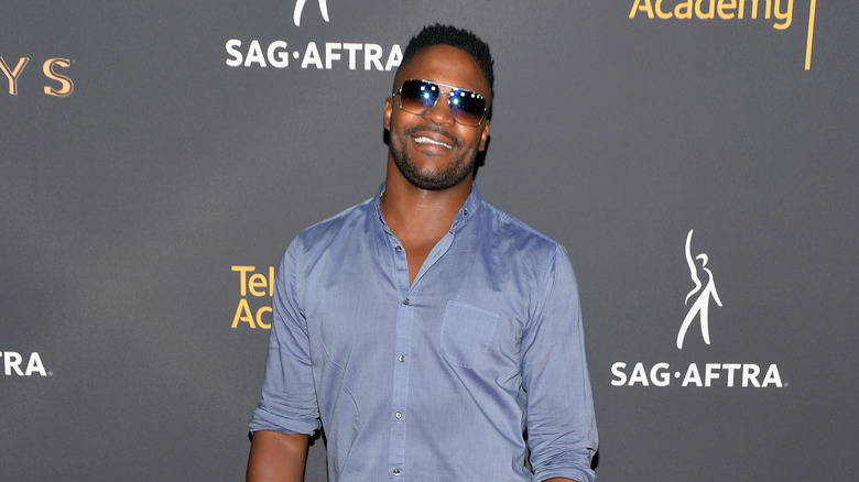 Duane Henry smiles on red carpet in sunglasses