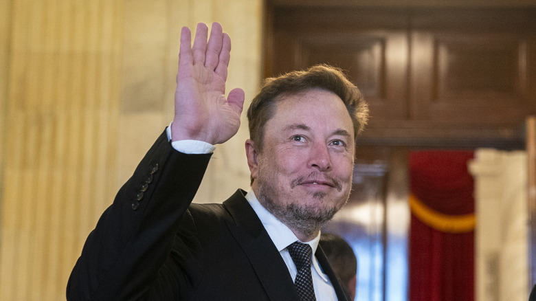 Elon Musk smiling and waving