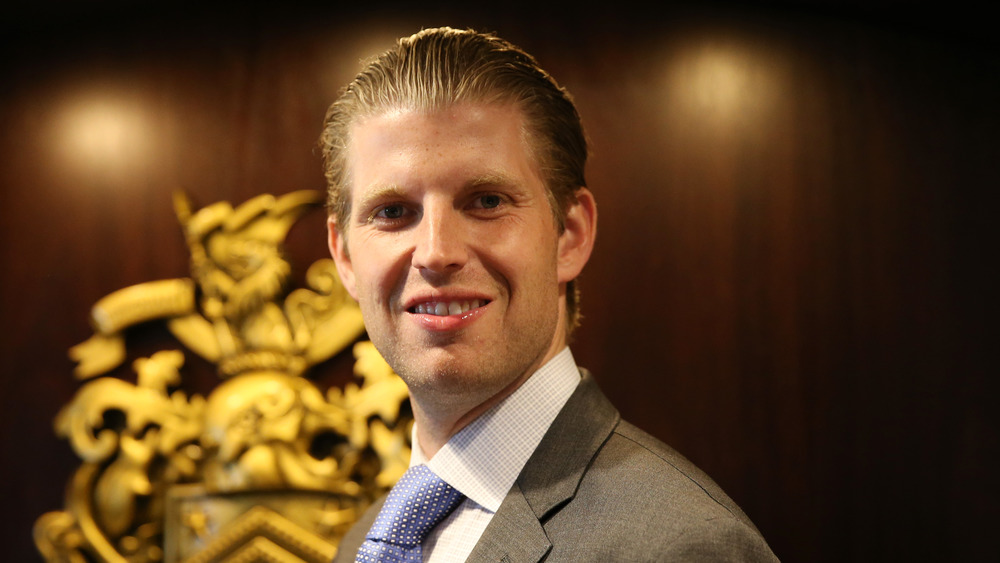 Eric Trump smiling in a lobby 