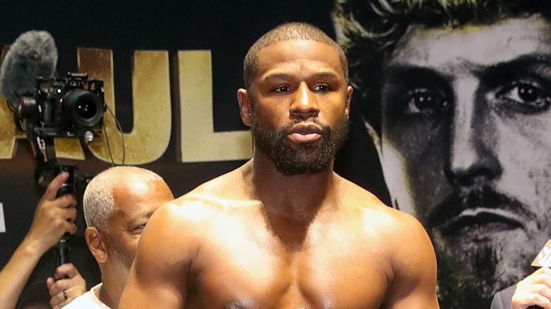 Floyd Mayweather stands shirtless at a boxing event