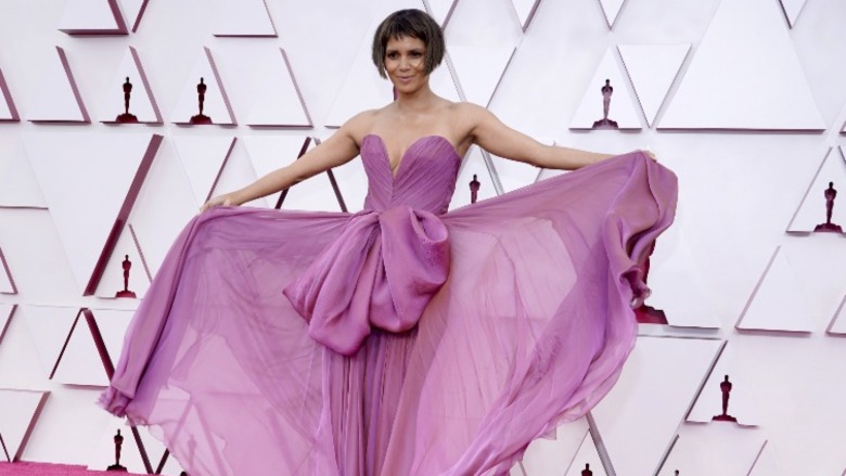 Halle Berry displaying the skirt of her dress on the red carpet in a short bob haircut