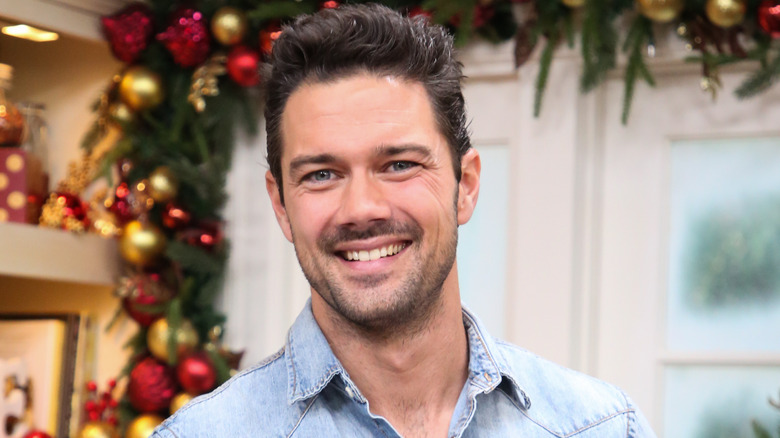 Ryan Paevey smiling with holiday decor