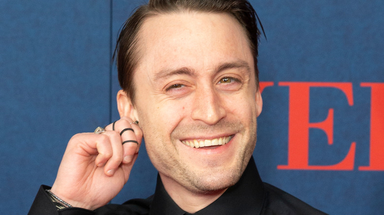 Kieran Culkin plays with his ear on the red carpet