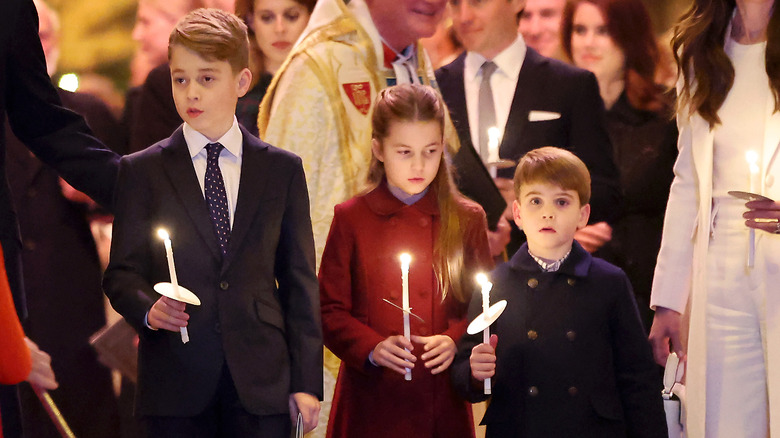 Prince George, Princess Charlotte, and Prince Louis holding candles