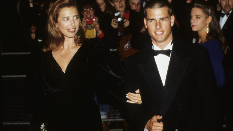 Mimi Rogers holds the arm of Tom Cruise in 1989