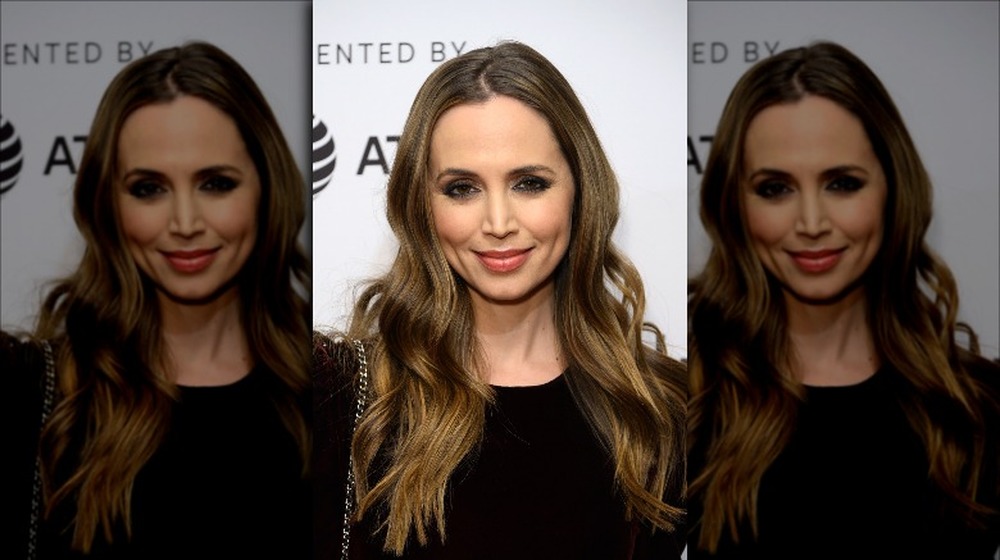 Eliza Dushku in all-black, posing with a small smirk