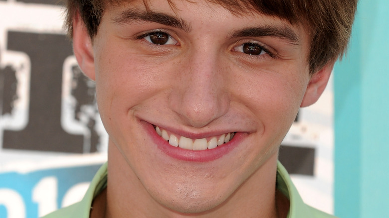 Lucas Cruikshank smiling on the red carpet in a lime green shirt