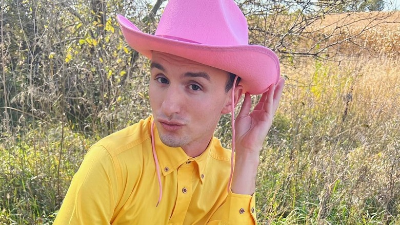 Lucas Cruikshank posing in a pink cowboy hat and yellow shirt