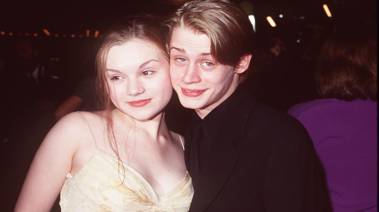 Macaulay Culkin and Rachel Miner smiling together at a film premiere for "The Mighty" in Los Angeles