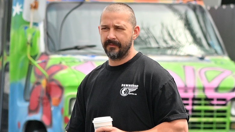 Shia LaBeouf walking with a coffee cup