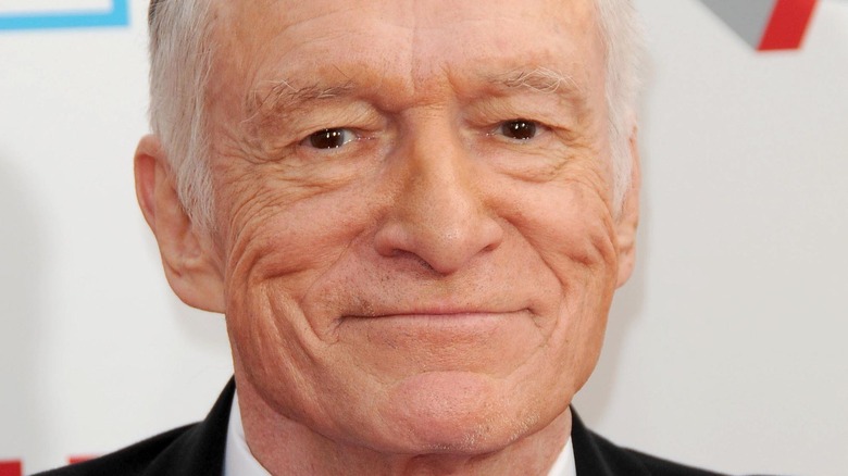 Hugh Hefner smiles on red carpet