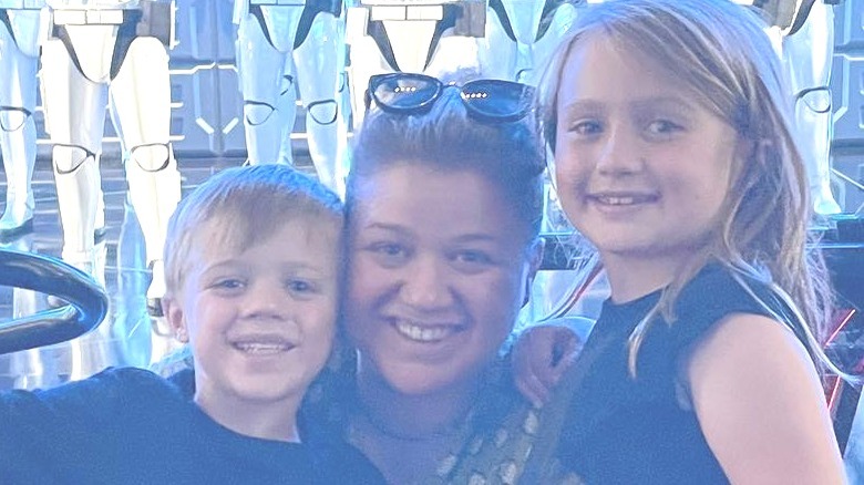 Kelly Clarkson hugging her kids at a theme park