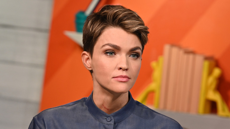 Ruby Rose poses in a gray outfit.