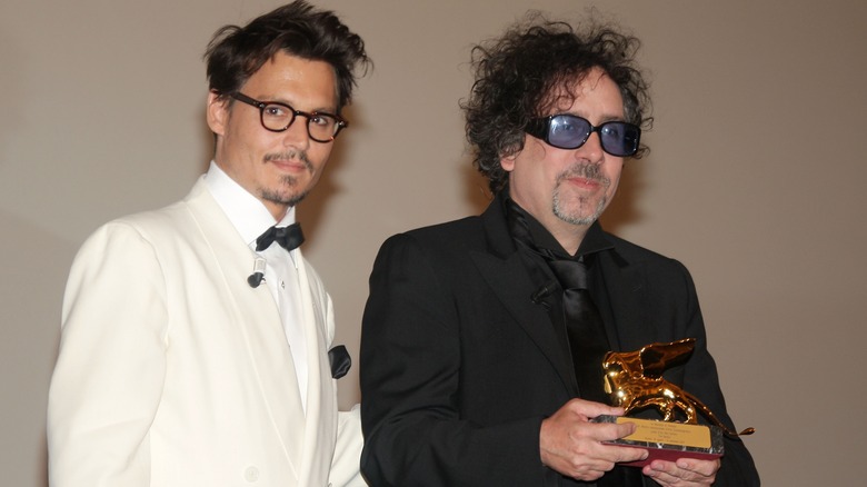 Johnny Depp and Tim Burton smile together at an award ceremony