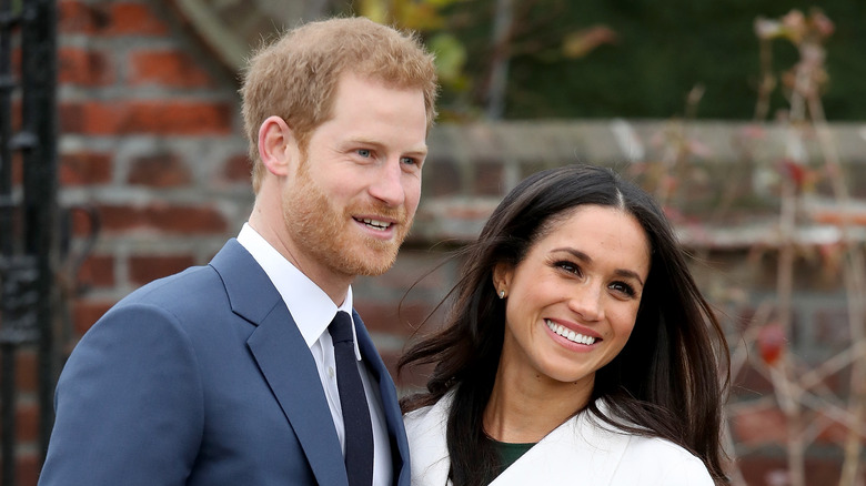 Meghan and Harry smiling during happier times