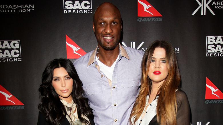 Kim Kardashian, Lamar Odom and Khloé Kardashian posing on the red carpet