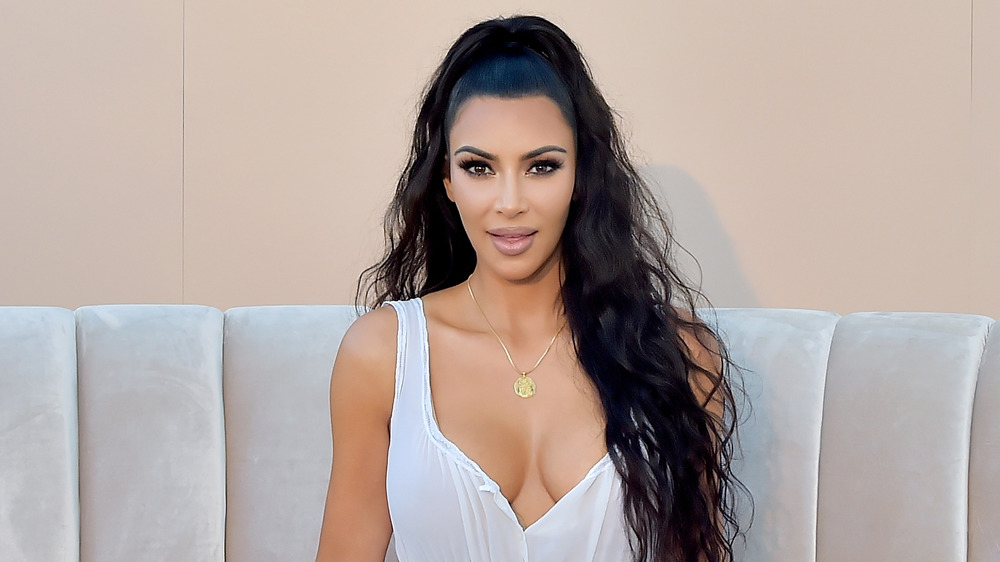 Kim Kardashian on a sofa at a KKW Beauty event 