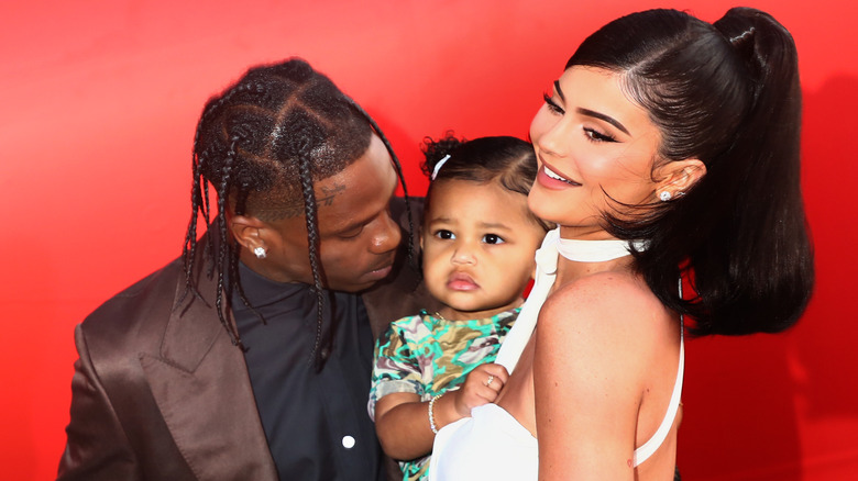 Kylie Jenner and Travis Scott posing with Stormi