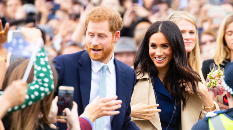 Prince Harry and Meghan Markle greet a crowd