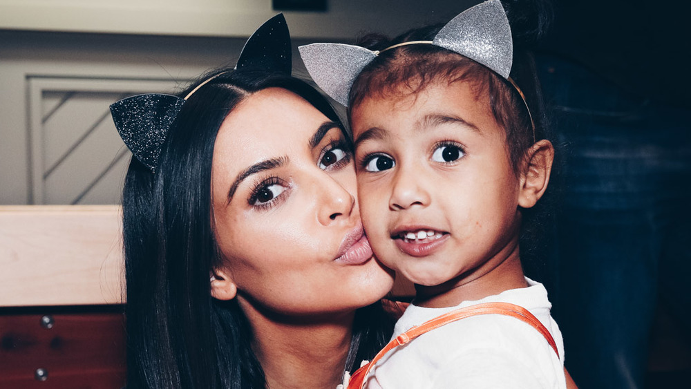 Kim Kardashian giving North West a kiss on the cheek