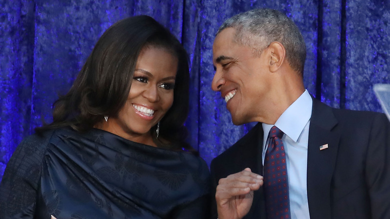 Michelle and Barack Obama smiling at each other