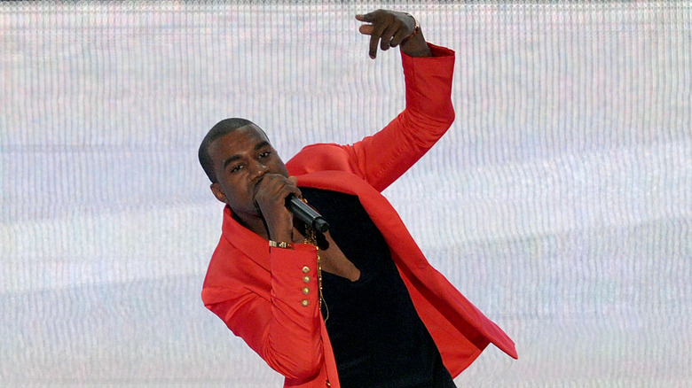 Kanye West performing in red jacket