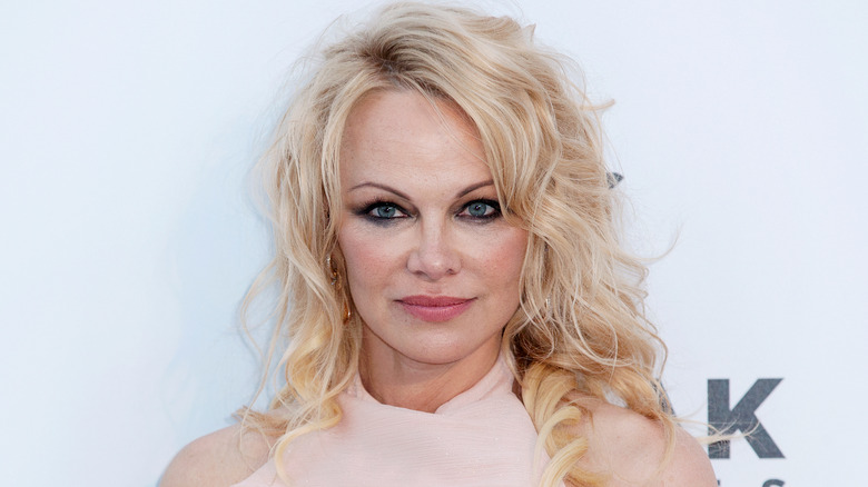 Pamela Anderson poses in rose-colored top