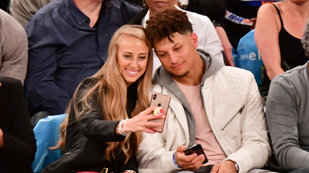 Brittany Matthew and Patrick Mahomes seated courtside