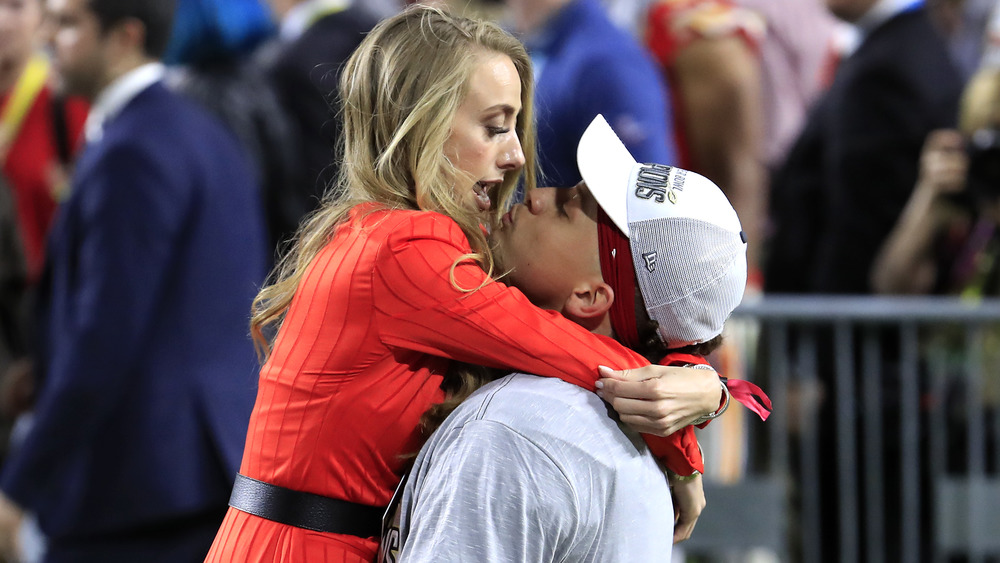 Patrick Mahomes and Brittany Matthews hugging on the football field