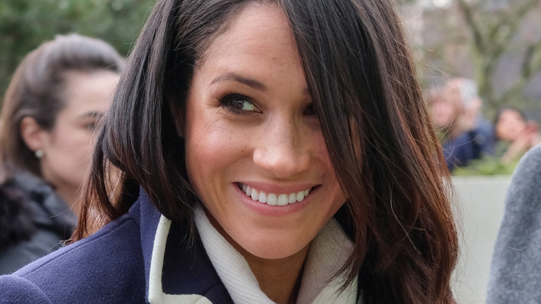 Meghan Markle smiling and looking to the side