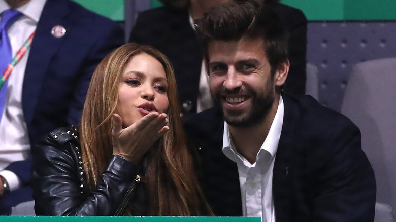 Shakira blowing kiss while Gerard Piqué watches game