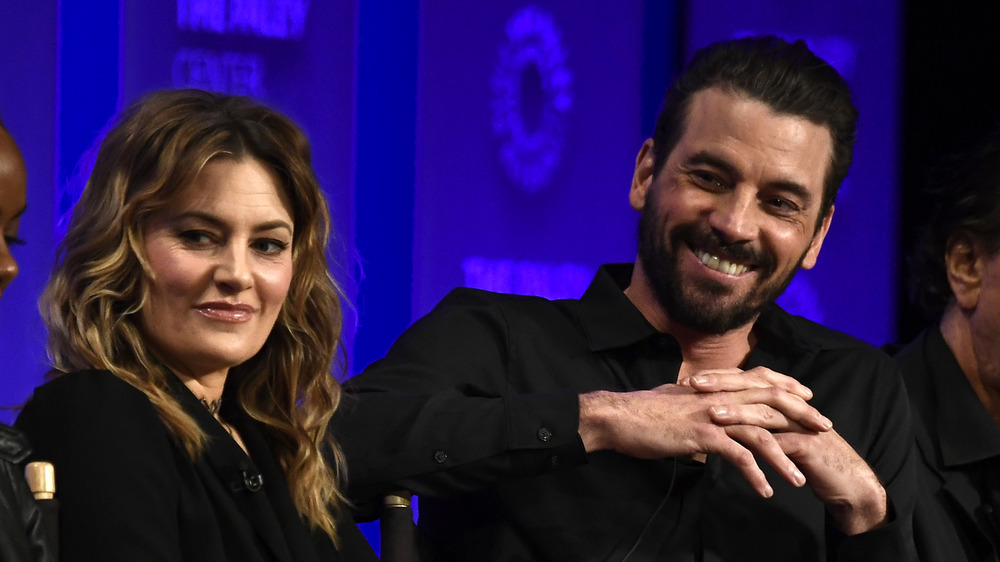 Skeet Ulrich, laughing, sitting, facial hair, wearing all black, sitting next to Mädchen Amick 