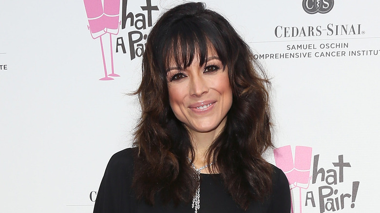 Liz Vassey smiling, wearing diamond necklace