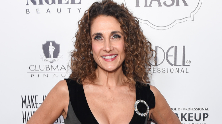 Melina Kanakaredes smiling, wearing diamond brooch