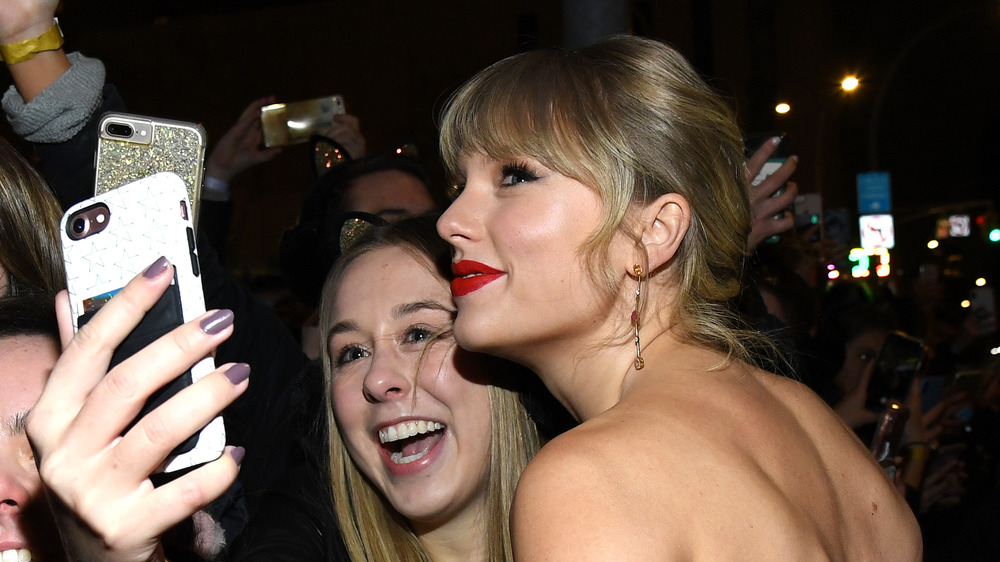 Taylor Swift posing with fans