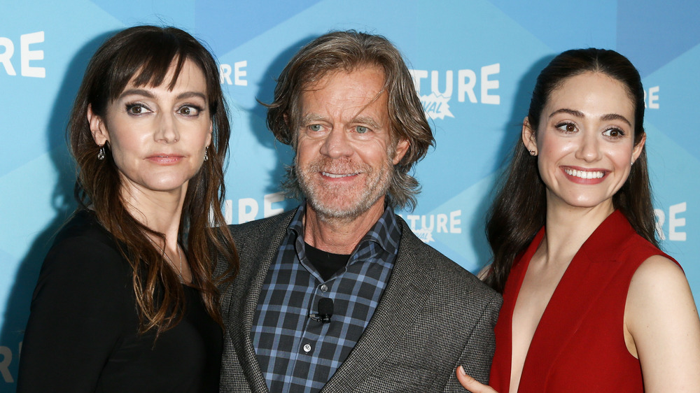 Emmy Rossum smiling on the red carpet with her Shameless co-stars